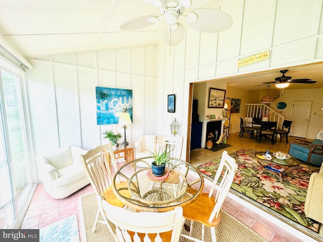 tiled dining space featuring vaulted ceiling and ceiling fan