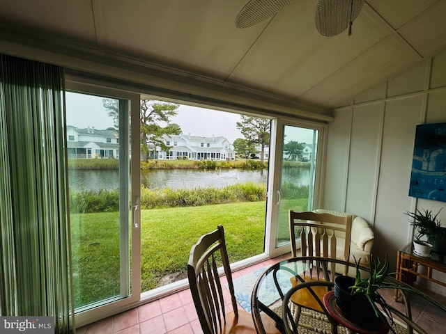 sunroom with ceiling fan, vaulted ceiling, a water view, and a wealth of natural light