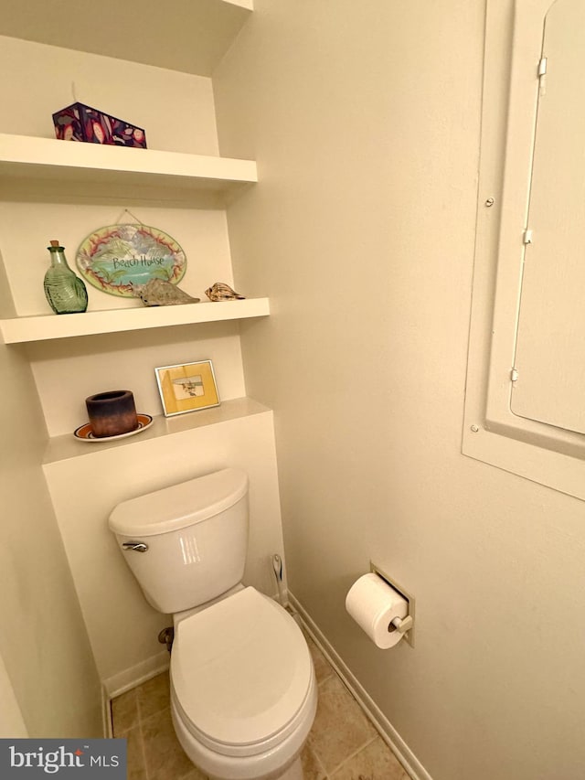 bathroom with tile patterned flooring, electric panel, and toilet