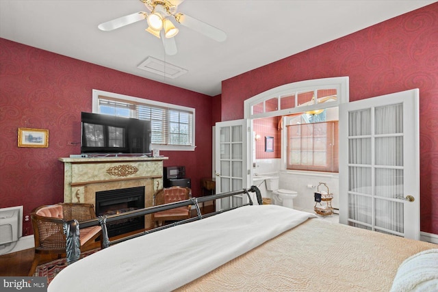 bedroom featuring ensuite bath, ceiling fan, and french doors