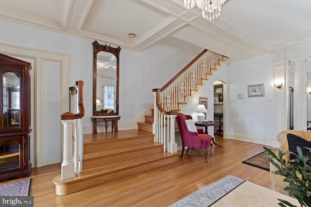 foyer featuring hardwood / wood-style floors, an inviting chandelier, and ornamental molding