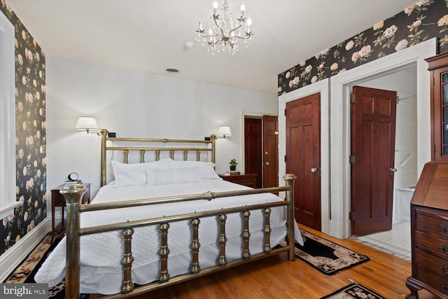 bedroom featuring hardwood / wood-style floors and an inviting chandelier