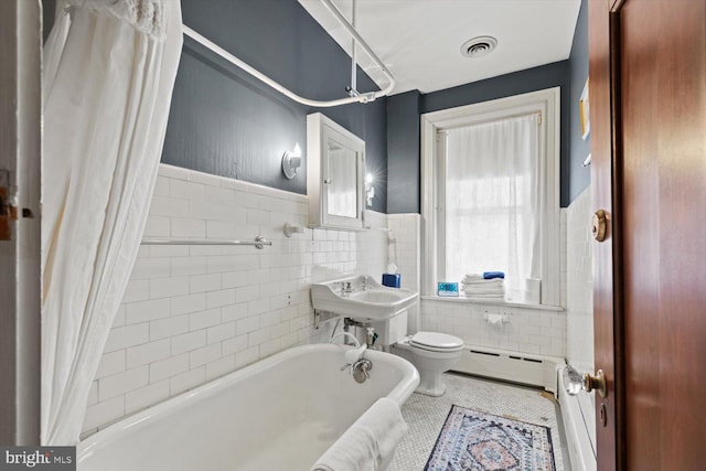 full bathroom with shower / bath combo, a baseboard radiator, tile walls, tile patterned flooring, and toilet