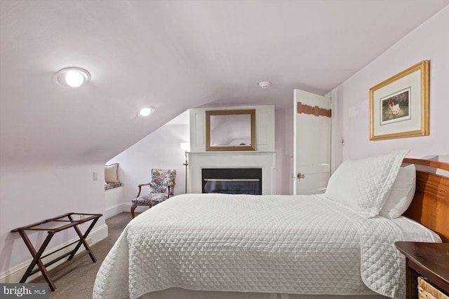 bedroom with carpet floors and lofted ceiling