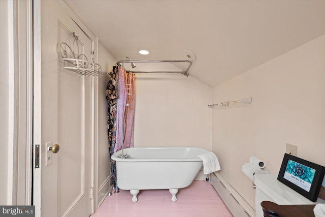 bathroom with toilet, lofted ceiling, a bath, and a baseboard radiator