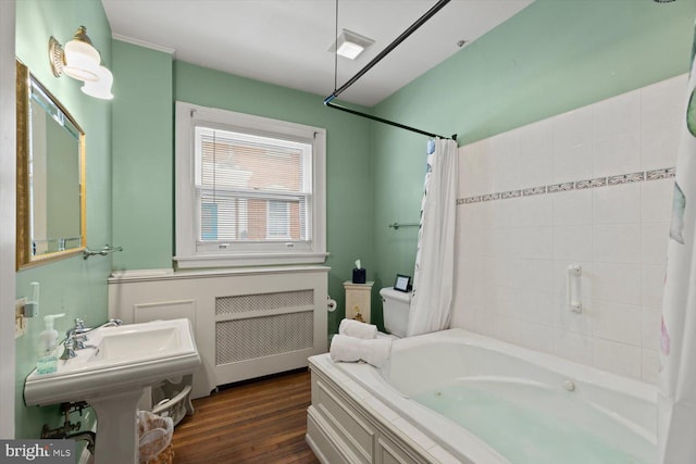 bathroom with hardwood / wood-style flooring, shower / bath combo with shower curtain, and radiator heating unit