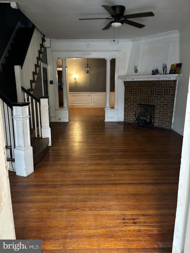 unfurnished living room with crown molding, dark hardwood / wood-style floors, and a brick fireplace