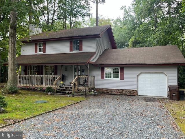 view of front property featuring a front yard, a garage, and covered porch