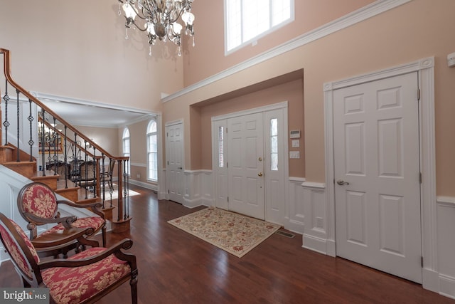 entryway featuring plenty of natural light, a high ceiling, and dark hardwood / wood-style floors