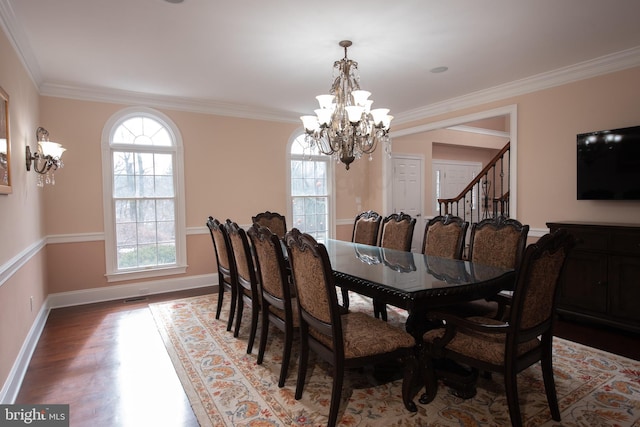 dining room with hardwood / wood-style floors, a notable chandelier, and ornamental molding