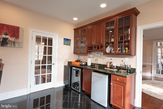 bar featuring stainless steel dishwasher, a wealth of natural light, wine cooler, and dark stone counters