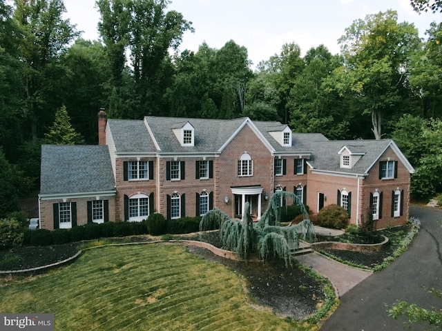 colonial inspired home with a front lawn