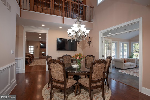 dining area featuring dark hardwood / wood-style floors, high vaulted ceiling, and a chandelier