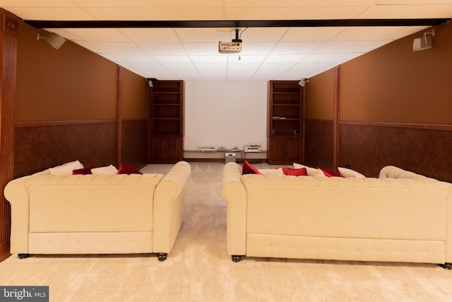 carpeted cinema featuring a drop ceiling