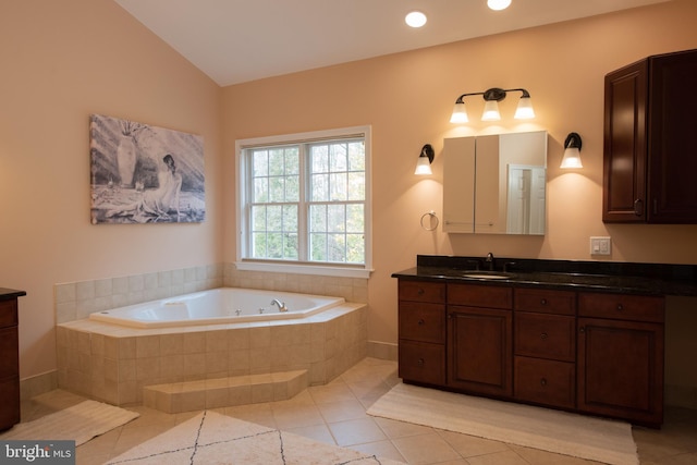 bathroom with tile patterned floors, tiled bath, vanity, and vaulted ceiling