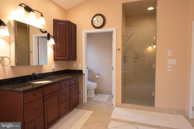 bathroom with tile patterned floors, a shower with door, vanity, and toilet