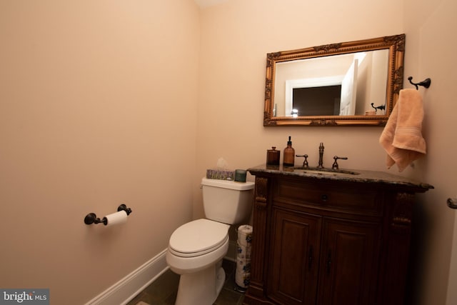 bathroom featuring tile patterned flooring, vanity, and toilet