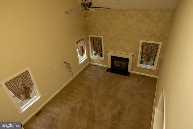 unfurnished living room featuring ceiling fan and carpet flooring