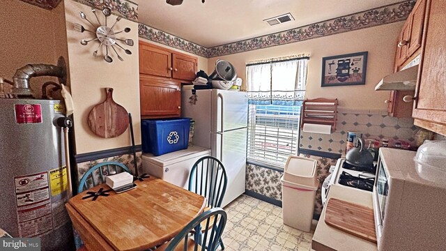 interior space with gas water heater and white appliances