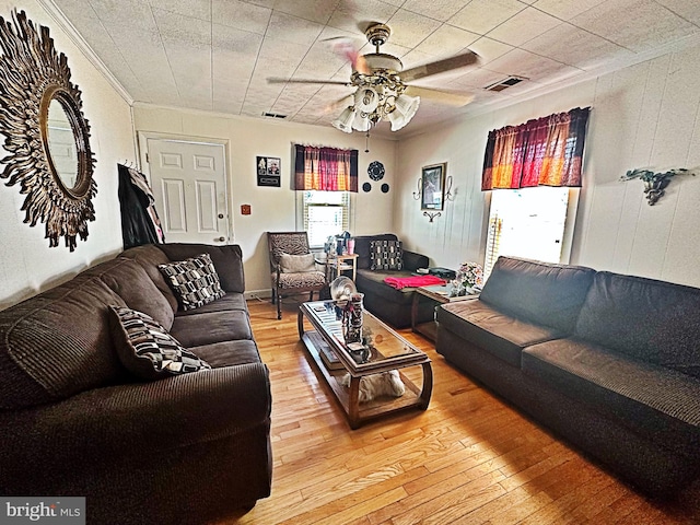 living room with ceiling fan, crown molding, and wood-type flooring