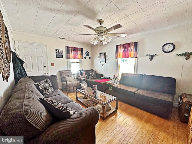 living room featuring ceiling fan, hardwood / wood-style flooring, and crown molding