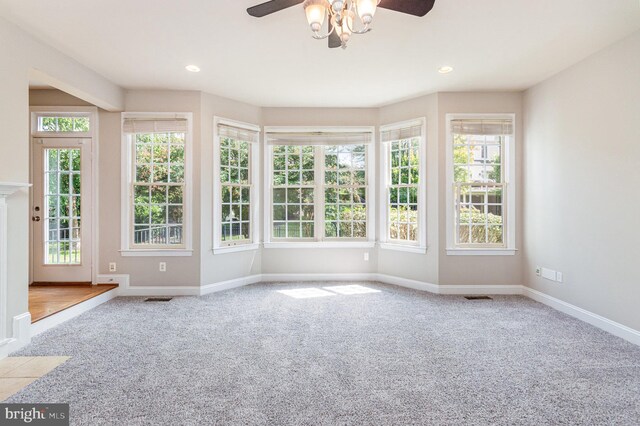 carpeted empty room featuring a wealth of natural light and ceiling fan