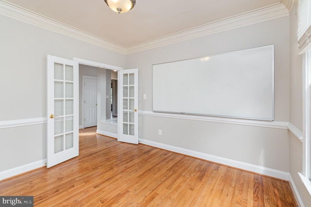 empty room with light hardwood / wood-style floors, french doors, and crown molding