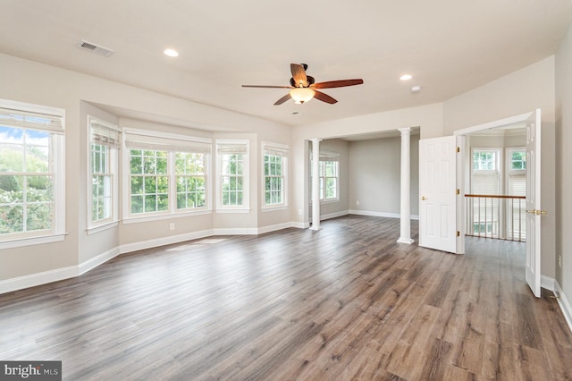 unfurnished living room with decorative columns, dark hardwood / wood-style flooring, and ceiling fan