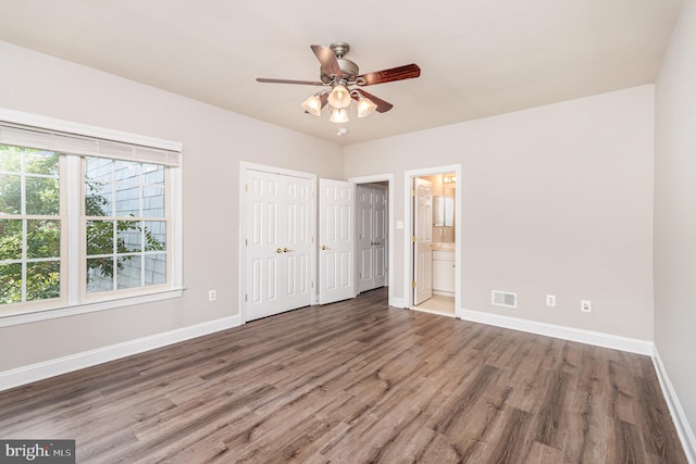 unfurnished bedroom with dark hardwood / wood-style floors, ceiling fan, and ensuite bathroom