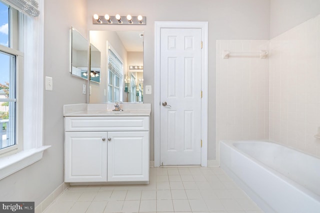 bathroom featuring tile patterned flooring, tiled shower / bath, and vanity