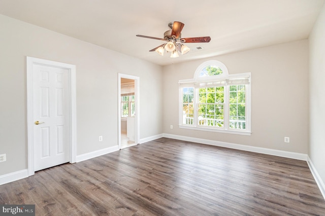 spare room with dark hardwood / wood-style flooring and ceiling fan