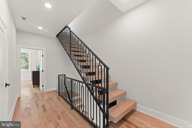 stairway with hardwood / wood-style floors