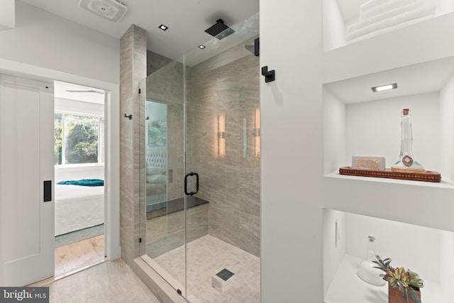 bathroom with hardwood / wood-style flooring and an enclosed shower