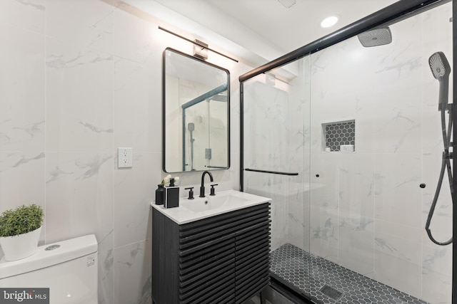 bathroom featuring vanity, a shower with shower door, and toilet