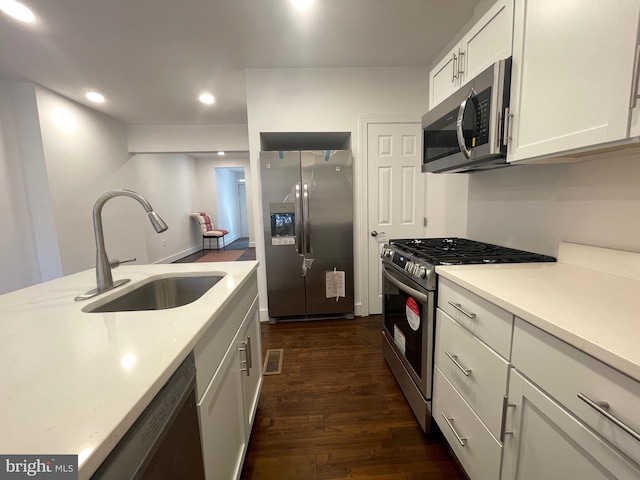 kitchen with dark hardwood / wood-style flooring, stainless steel appliances, white cabinets, and sink