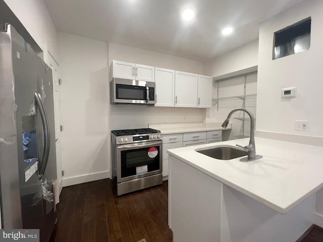 kitchen featuring kitchen peninsula, white cabinetry, sink, and stainless steel appliances