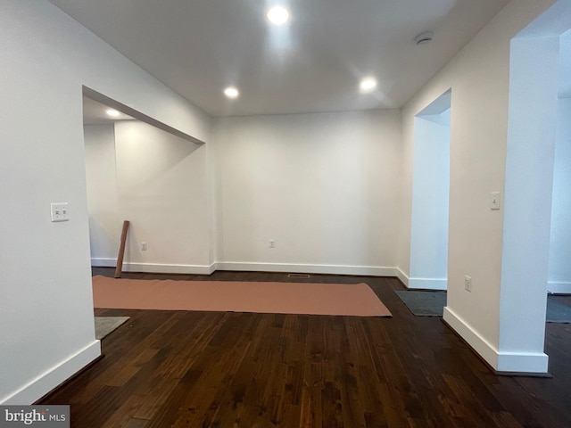 basement with dark hardwood / wood-style flooring