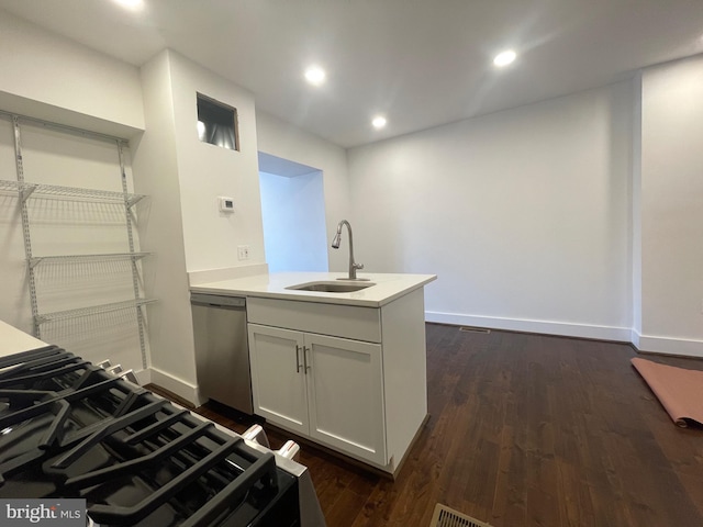 kitchen with dark wood-type flooring, sink, white cabinets, kitchen peninsula, and stainless steel dishwasher