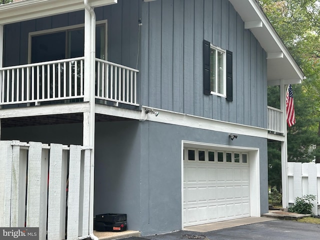 view of property exterior featuring a balcony and a garage