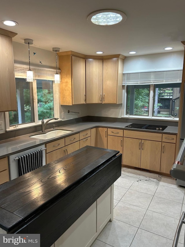 kitchen featuring decorative light fixtures, sink, light tile patterned floors, and a wealth of natural light