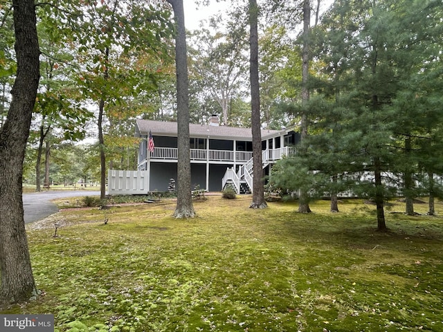 view of front of house featuring a deck and a front lawn