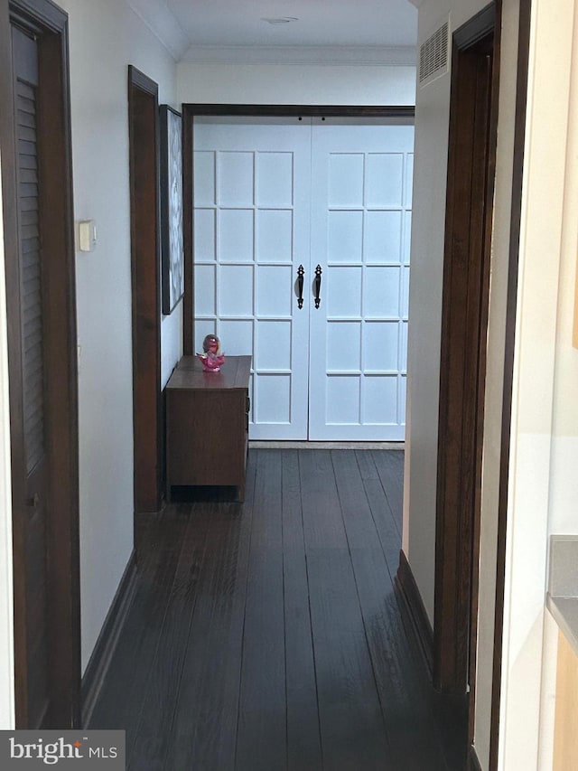 hall featuring ornamental molding and dark wood-type flooring