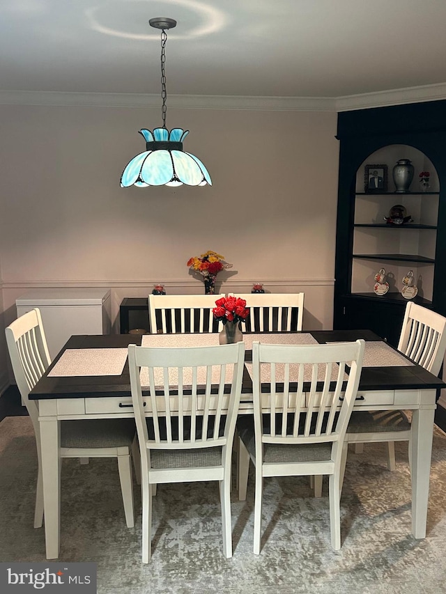 carpeted dining room with crown molding