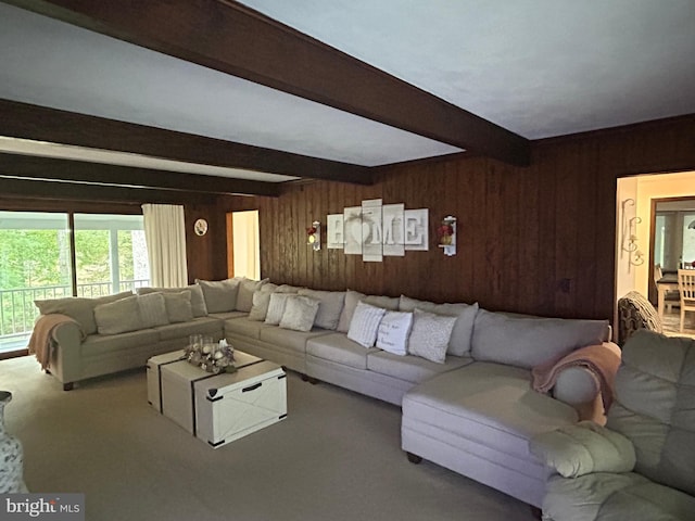 living room featuring beamed ceiling, wooden walls, and carpet