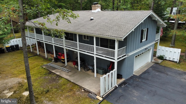 rear view of property with a garage and a lawn