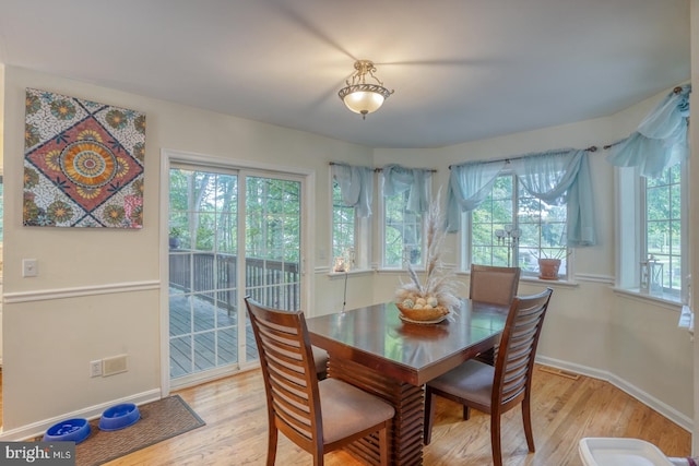 dining room with light hardwood / wood-style floors and a healthy amount of sunlight