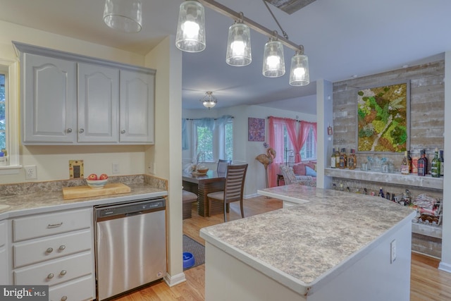 kitchen with light hardwood / wood-style flooring, a center island, hanging light fixtures, and stainless steel dishwasher