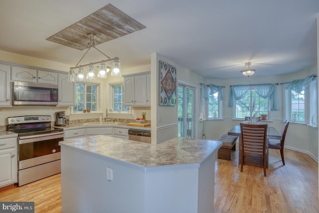 kitchen with pendant lighting, appliances with stainless steel finishes, and white cabinetry