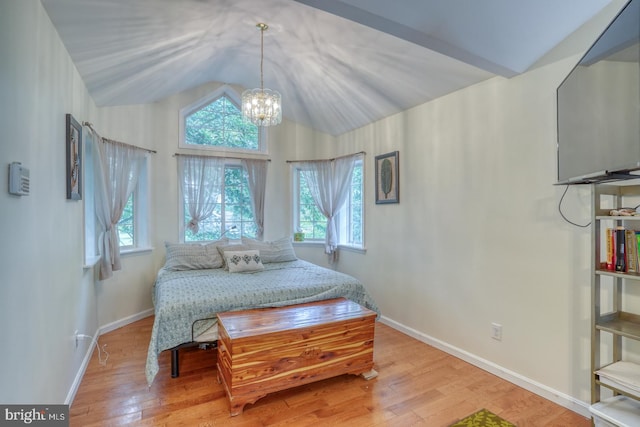 bedroom featuring vaulted ceiling, a notable chandelier, and light hardwood / wood-style floors