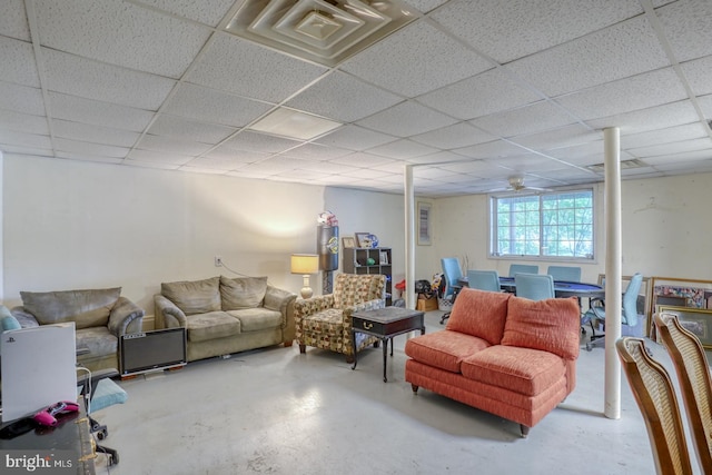 living room with a drop ceiling and concrete floors